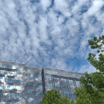 Concrete Clouds, Latin American Square, Canberra, with fluffy chequered clouds across the sky reflected in a glass covered ten-storey building