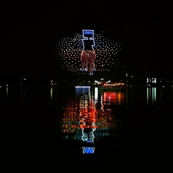 Ned Kelly Remastered, FLIGHT Drone SkyShow, Lake Burley Griffin, Parkes, with hundreds of drones in the night's sky recrating Sindey Nolan's famous Ned Kelly artwork reflected in the waters of Lake Burley Griffin