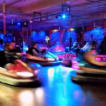 The Dodgem Cars, with about half-a-dozen dodgem cars zooming from right to left and some in a blur