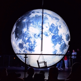 Moon Swing, Barangaroo Reserve, with a large glowing moon which has an empty swinging seat in front of it