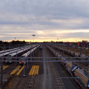 Waiting For A Train, Enfield Trainyards, South Strathfield, with countless train lines spanning left and rights going into the distance where it meets a sunset