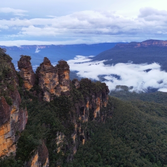 Foggy Valley, Echo Point, Katoomba, with the Three Sisters surrounded by low clouds in the valley below, with blues and greens in the sky and the valley