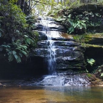 The Long Drop, The Pool of Siloam, Leura, with a cascading five-storey waterfall falling over a two-storey cave into a crystalline pool all surrounded by green