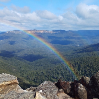 Rainbow Valley Road, Princes Rock Lookout, Wentworth Falls, with a rainbow centre-frame stretching across the valley behind