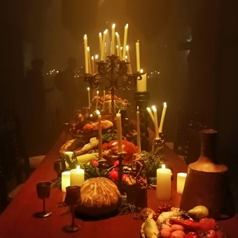 Royal Feast, House Of The Dragon Exhibit, Wynyard Tunnels, with a candle-lit table filled with prop food  and a red tablecloth in an otherwise dimly lit room